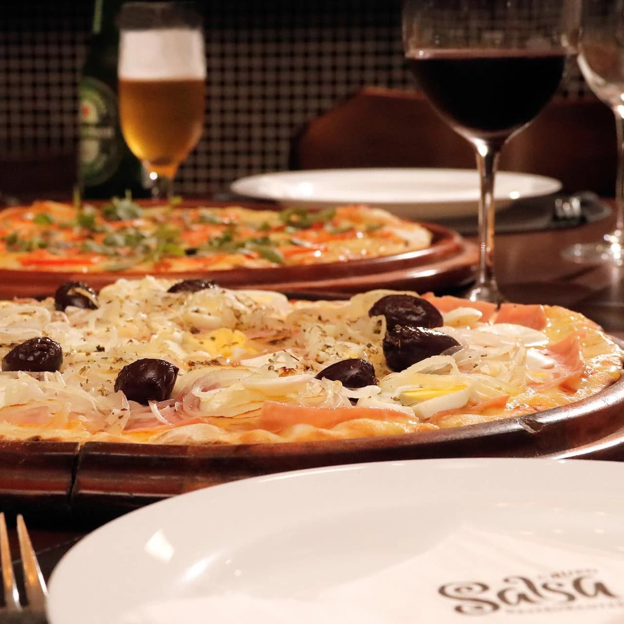 Mesa da Salsa Pizzaria com pizzas, chopp e vinho